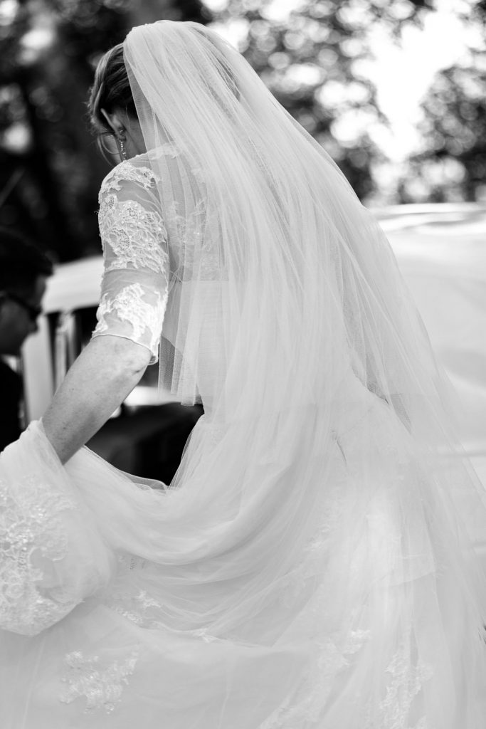 black and white image of bride getting out of the white wedding car at Saint George's Anglican Church Parktown Johannesburg
