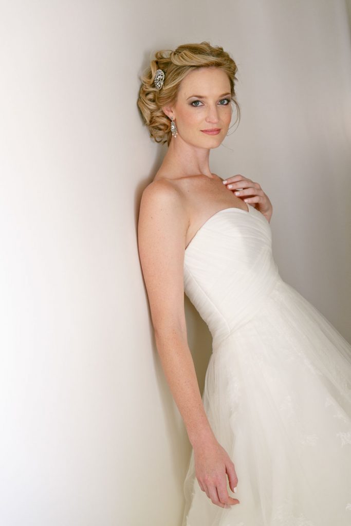 English bride leaning against a white wall in Parktown Johannesburg