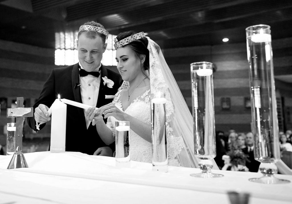 Bride and Groom lighting candles in the church