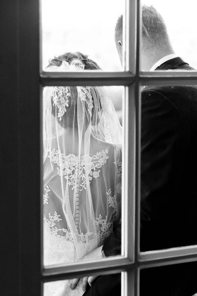 A couple standing behind the window at the Fourseasons Hotel The Westcliff