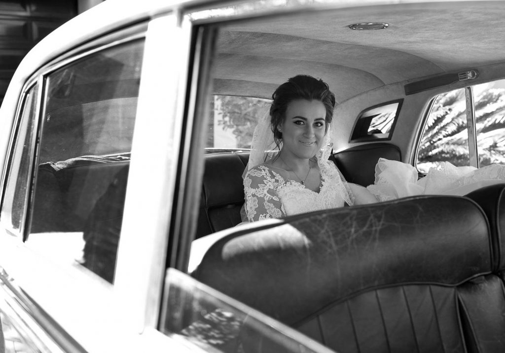 Bride sitting in the wedding car at The Westcliff Hotel