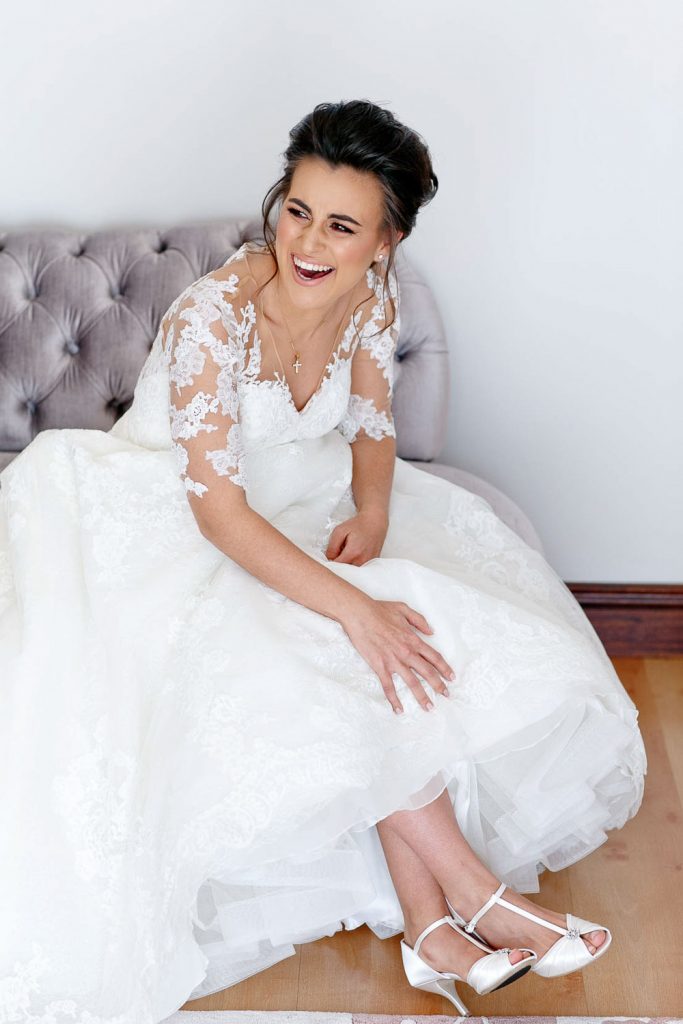 bride sitting on the chair and laughing at The Westcliff Hotel