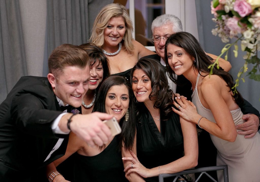 family taking a photograph at the wedding Four Seasons Hotel The Westcliff