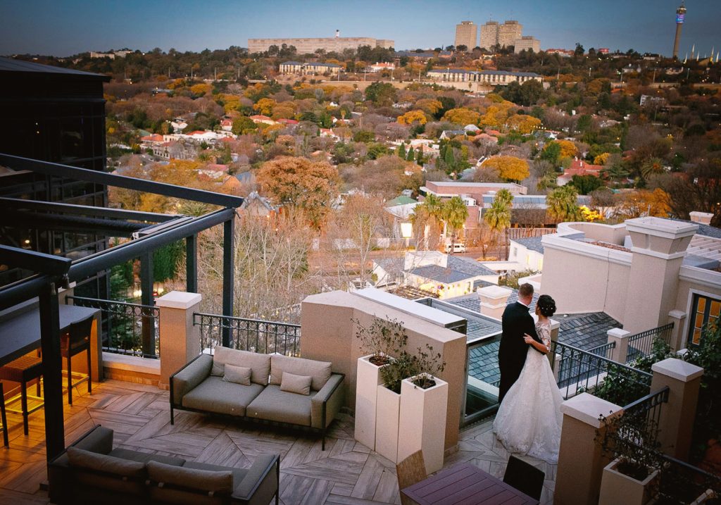 wedding couple on the balcony at wedding guests at Four Seasons Hotel The Westcliff