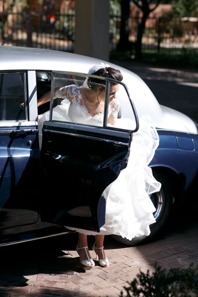 Lebanese bride getting out of a blue wedding car at the Fourseasons Hotel The Westcliff Hotel Johannesburg