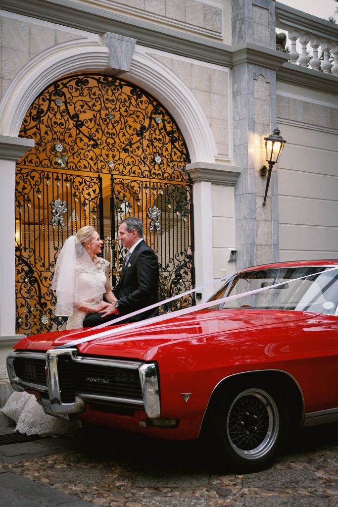Wedding couple portraits with a red car at Illyria House in Pretoria
