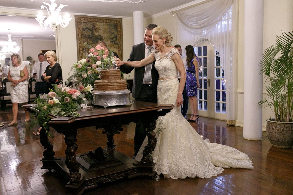 Bride and groom cutting their chocolate brown wedding cake at Illyria House in Pretoria