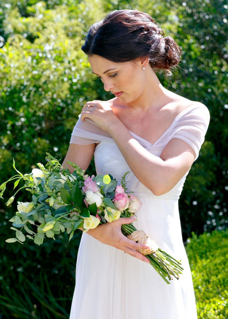 bride holding pink and white rose wedding boutique