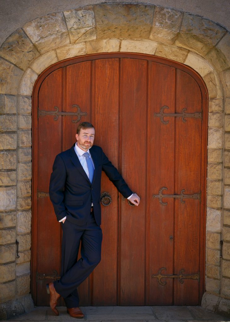 Groom in a blue suite standing outside the Saint Columba's Presbyterian Church in Parkview