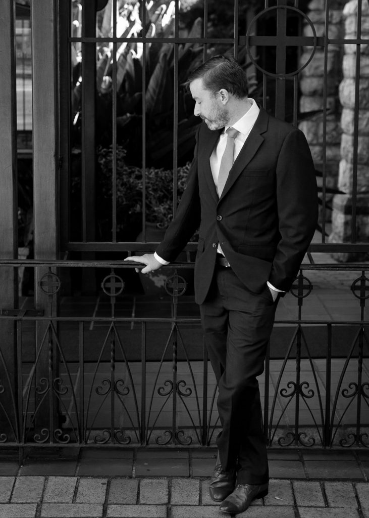 black and white photograph of the groom standing outside the Saint Columba's Presbyterian Church in Parkview