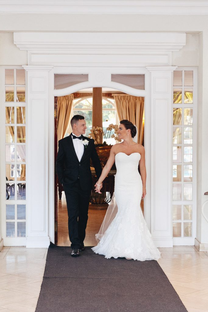 couple walking through the main doors at wedding guests at Summer Place Sandton