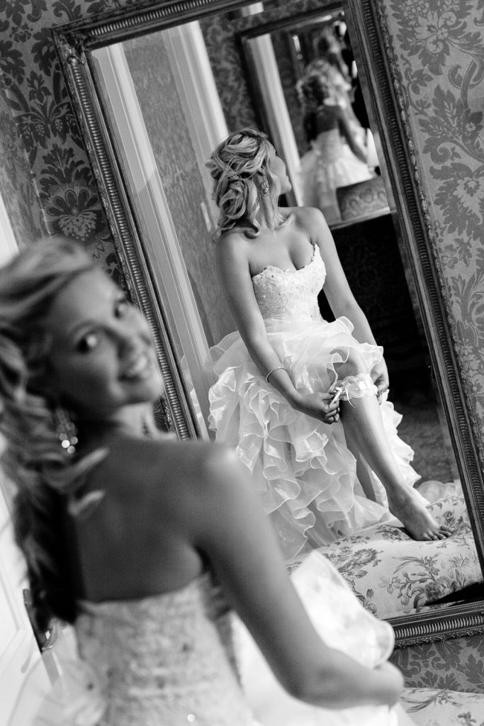 the black and white image of the bride putting on her garter at Palazzo Hotel Montecasino