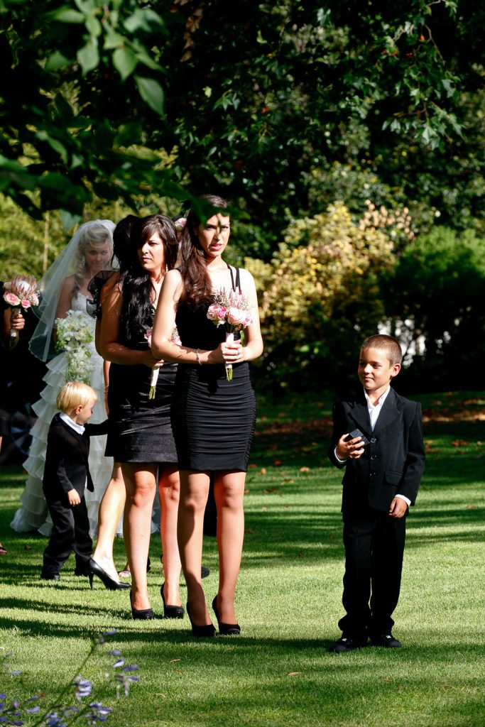 bridesmaids in black dress walking on the grass at Longmeadow Farm Fourways