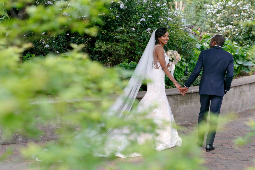 bride and groom walking hand in hand at Beechwood Gardens in Hyde Park Sandton
