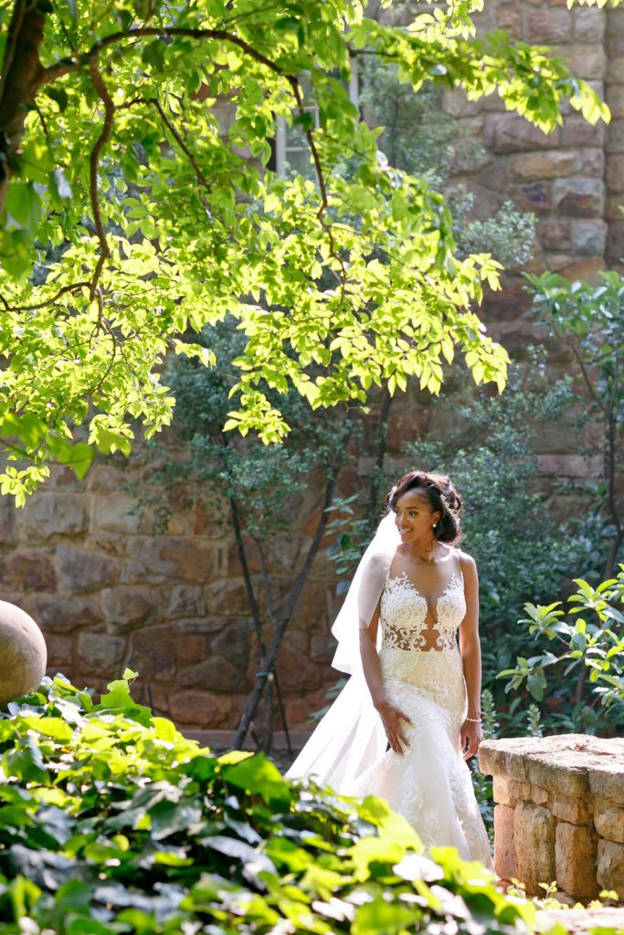 bride walking under the green trees at Beechwood Gardens in Hyde Park