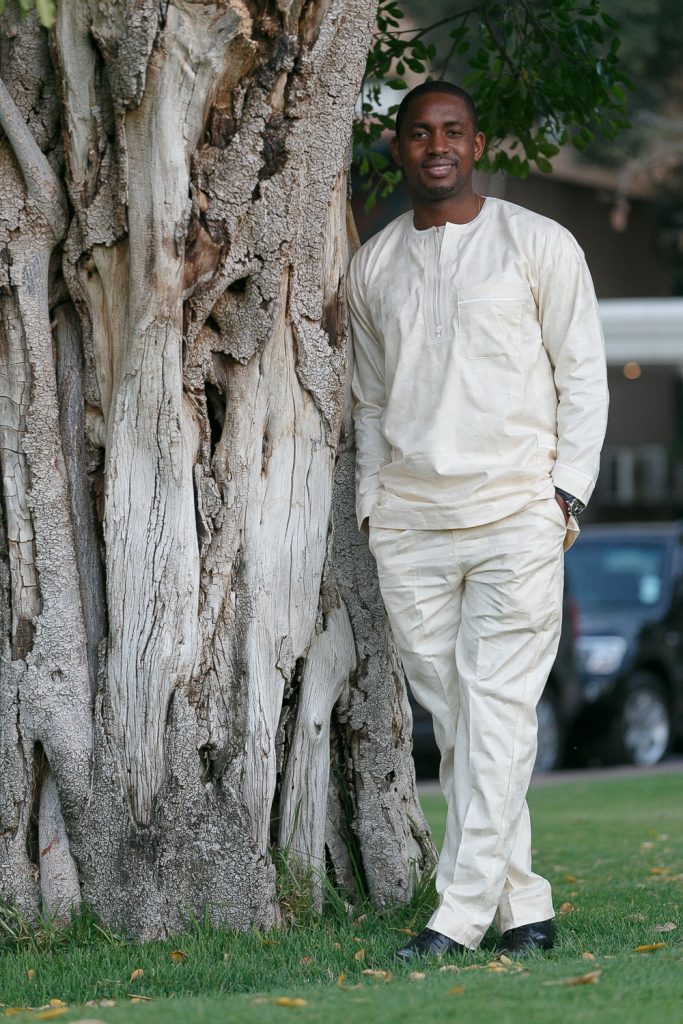 groom leaning against the tree at the Grand Palm Hotel Botswana
