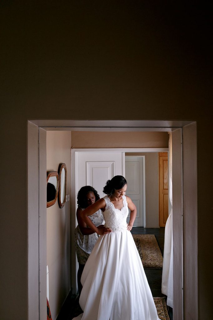 African bride getting dressed in her room at her hotel in Gabarone Botswana