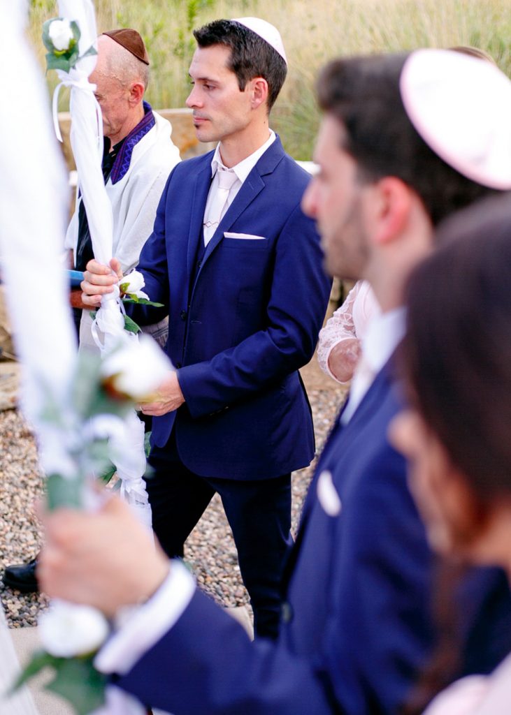 Jewish men holding the canopy poles at the Chuppah