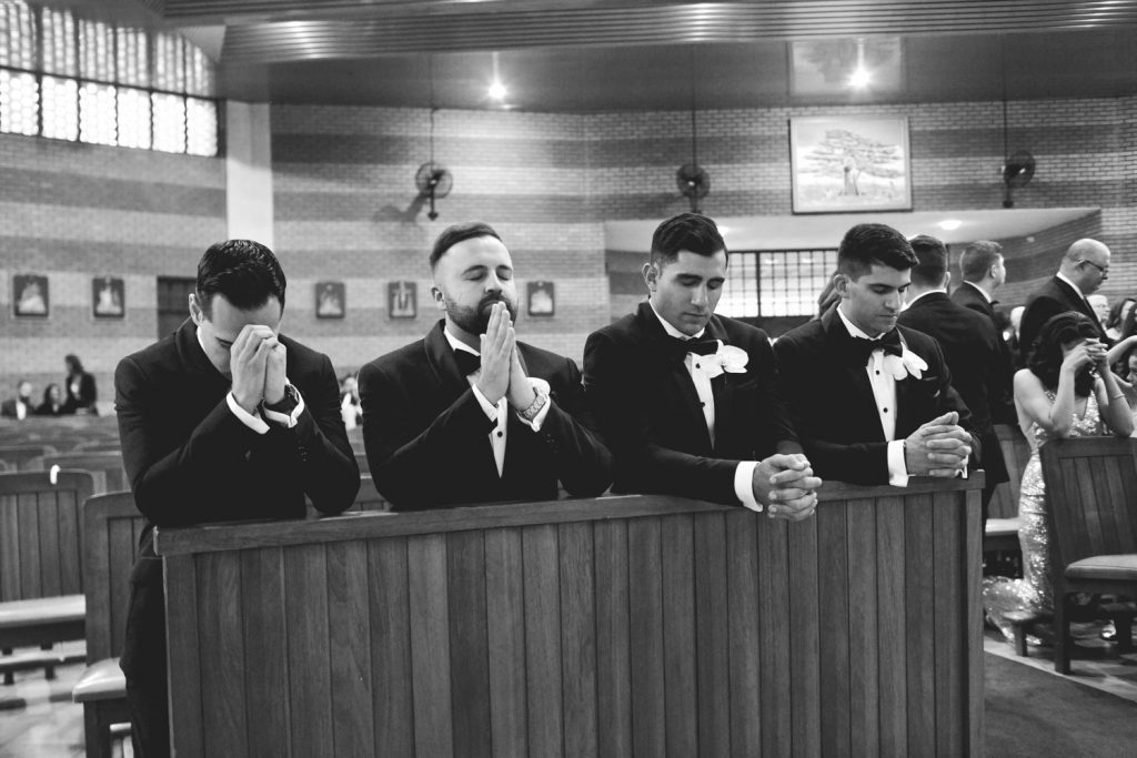 black and white image of groomsmen praying at Walter Edwin Clack decor images at the Maronite Catholic Church in Woodmead