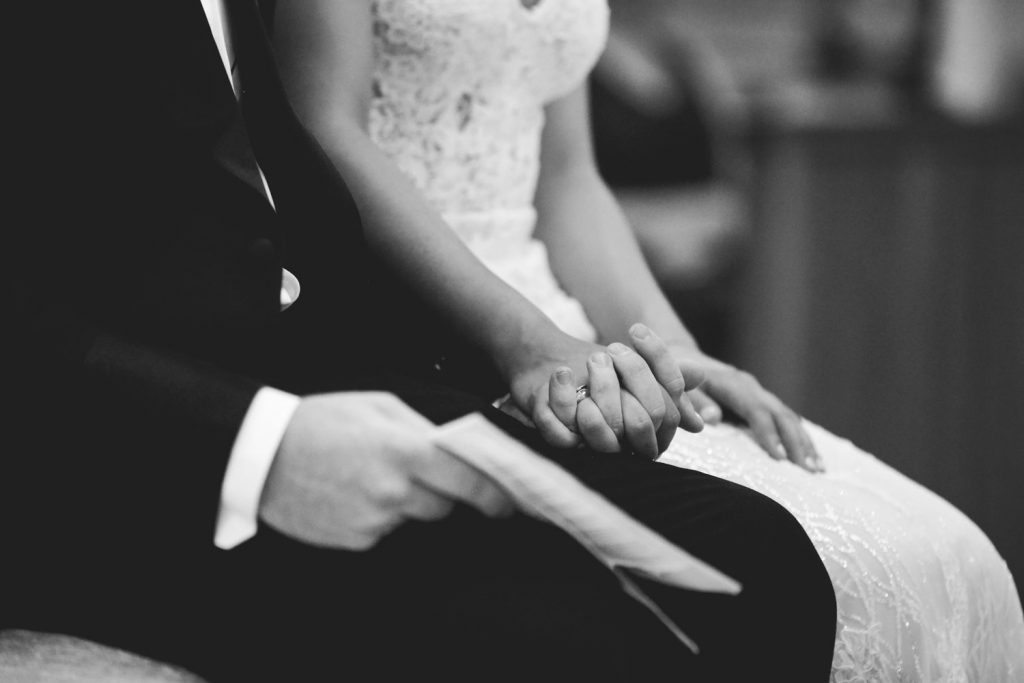 black and white image of couple holding hands the Maronite Catholic Church in Woodmead