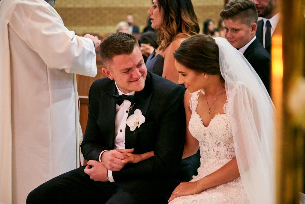 groom smiling at the bride at Our Lady of Cedars on Woodmead