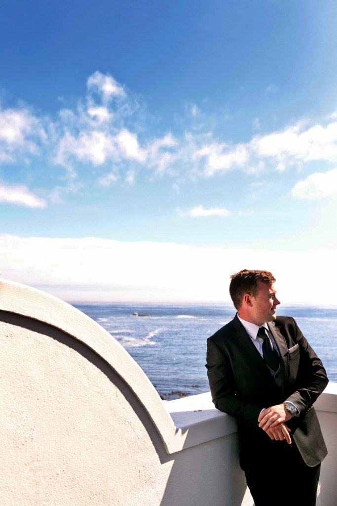 groom standing on the balcony overlooking the Atlantic Ocean