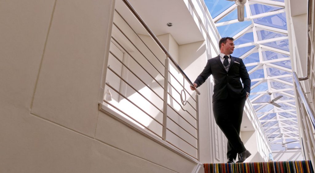 Groom standing at the top of the staircase at the Twelve Apostles Hotel