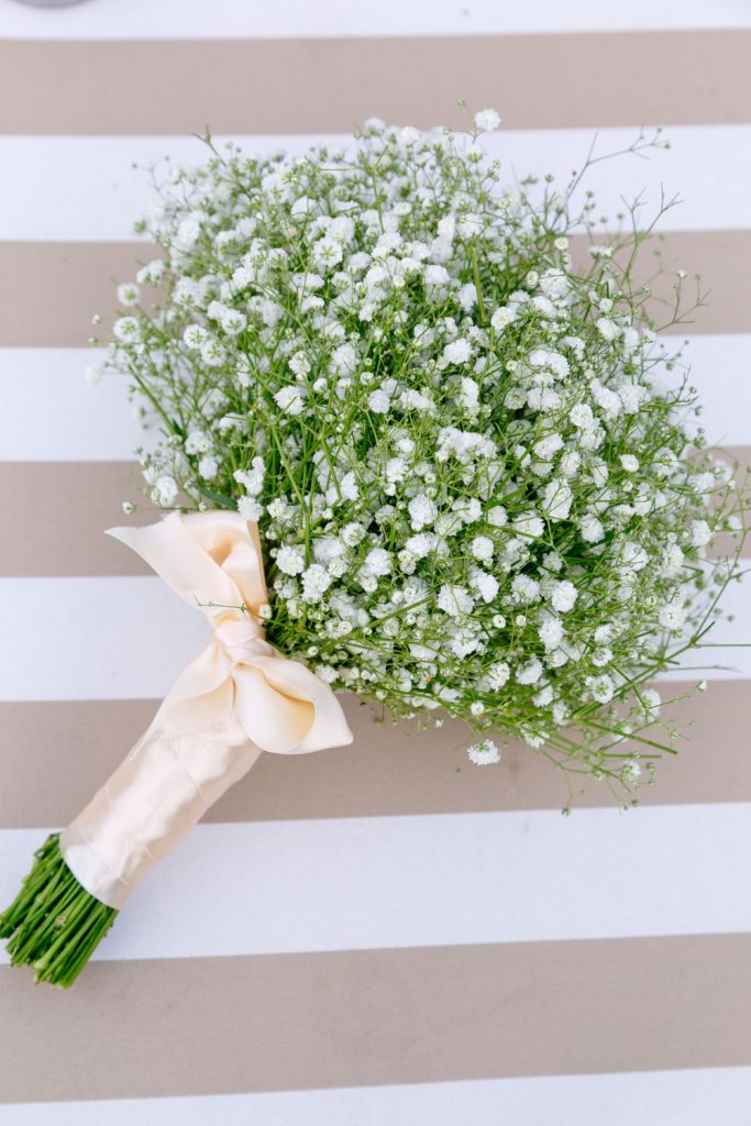 bridesmaids white flower boutique resting on a brown and white table cloth