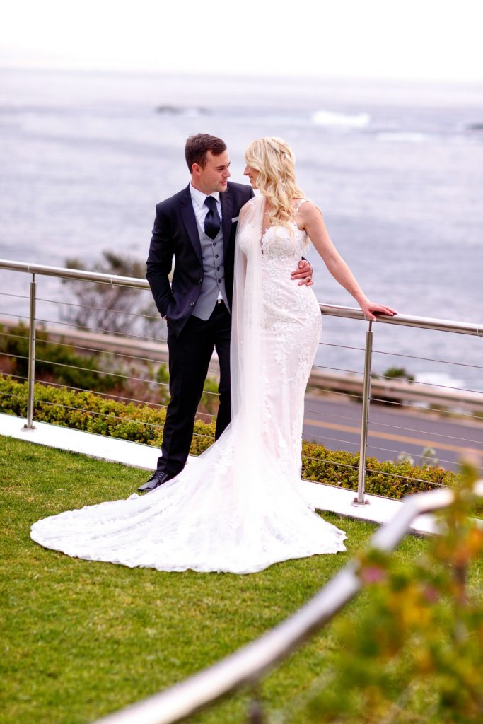 Wedding couple standing in the gardens overlooking the Atlantic Ocean in Camps Bay