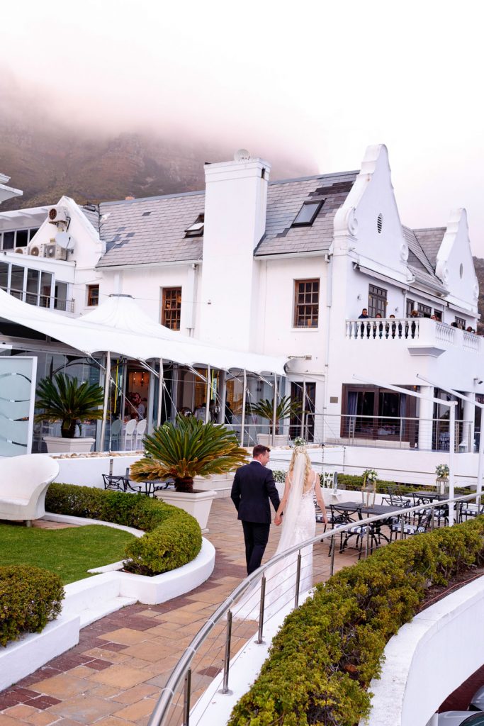 married couple walking to the reception hall at the Twelve Apostles Hote in Camps Bay