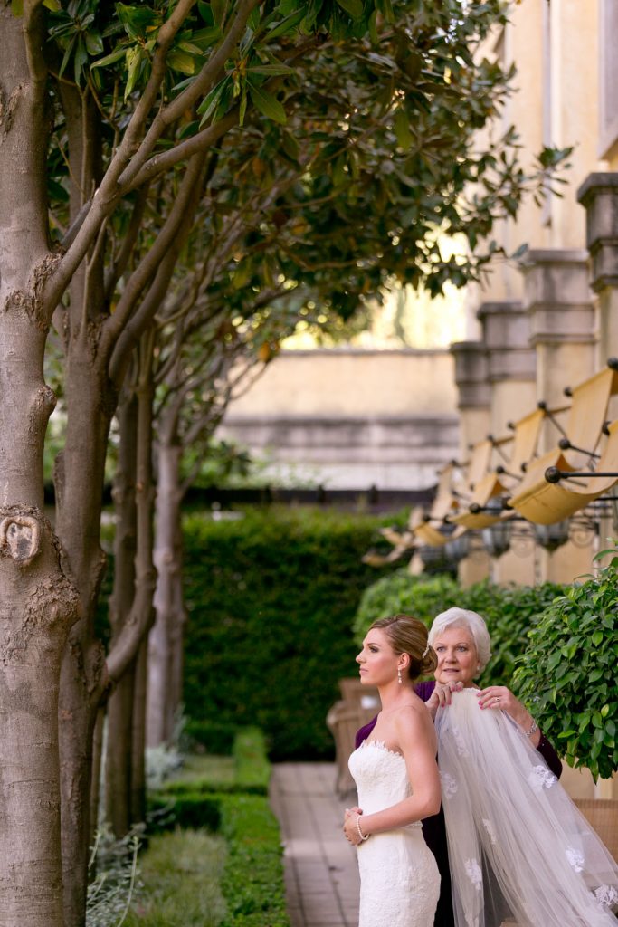 mother of the bride putting in the brides wedding veil at Johannesburg bride posing in front of the fountains at The Palazzo Hotel