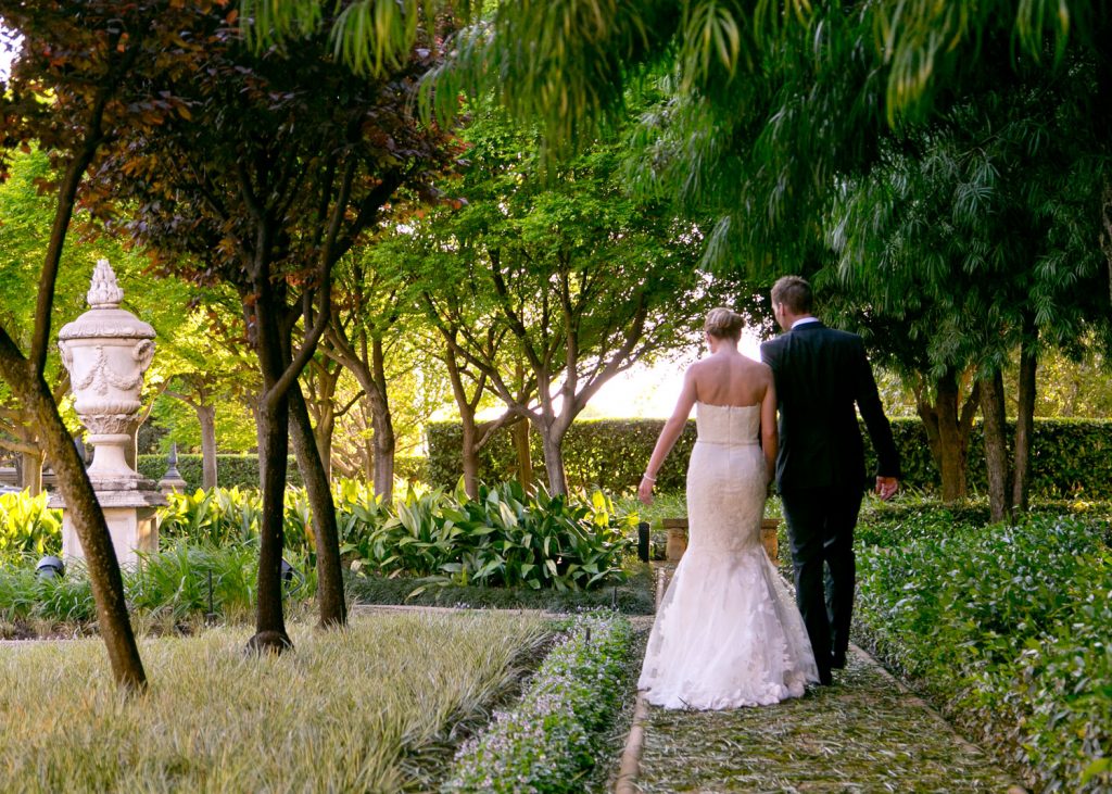 bride and groom walking in the green gardens at The Palazzo Hotel Montecasino in Johannesburg