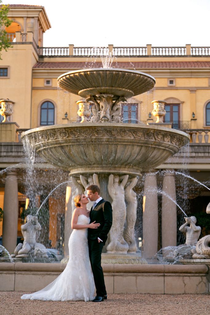 bride and groom standing in front of the grand fountains at The Palazzo Hotel Montecasino in Johannesburg