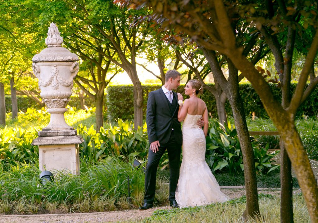 bride and groom posing in the gardens at Johannesburg wedding photographer for The Palazzo Hotel Montecasino in Johannesburg