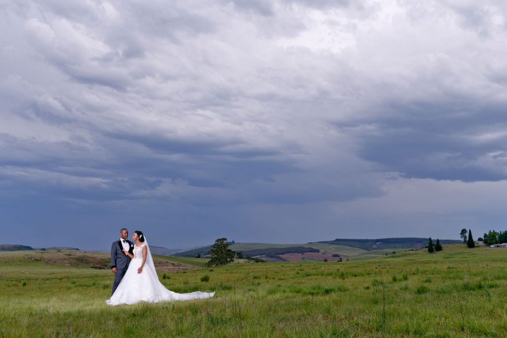 African wedding couple standing on a green hill at Brahman Hills Nottingham Road Natal Midlands