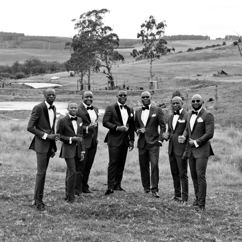 Groomsmen in black tuxedos drinking champagne at Brahman Hills Nottingham Road