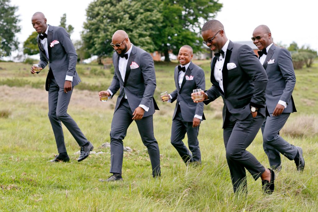 African wedding party walking through the Green Grass Hills at a Nottingham Road Wedding Venue in the Natal Midlands