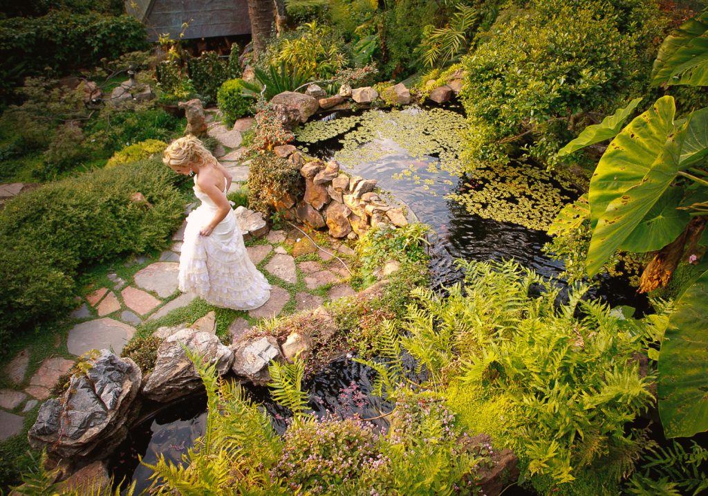 Bride in a white dress walking through the gardens at Shepstone Gardens