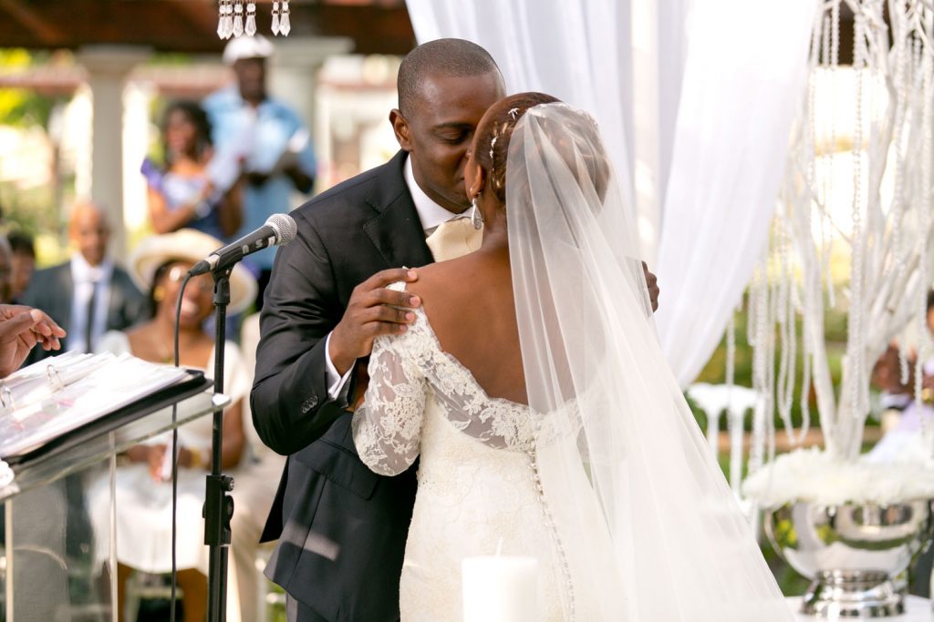 groom kissing the bride at an African wedding.