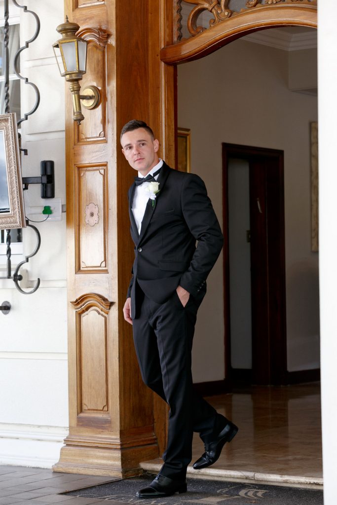 Groom in a black wedding suite walking out of Summerplace Sandton Wedding Venue