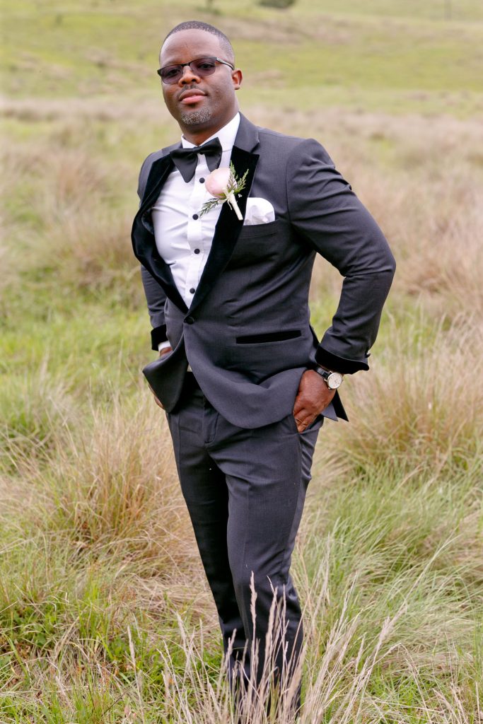 African Groom standing in the tall green grass at Brahman Hills Nottingham Road Natal Midlands
