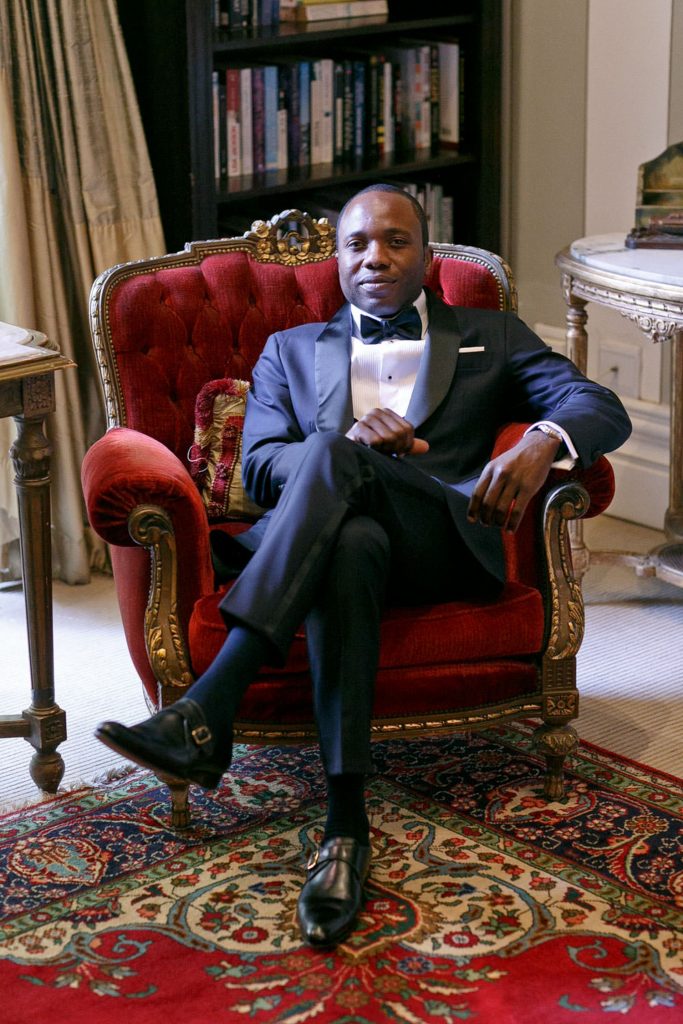 The Groom sitting in a red chair at Le Chatelat in Sandton