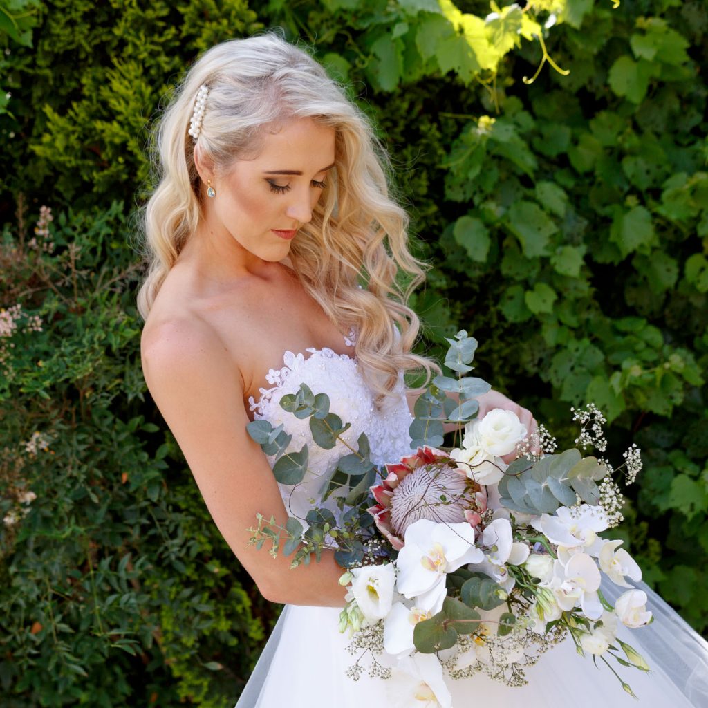 Lezar Opstal Weddings bride posing with her protea wedding bouquet