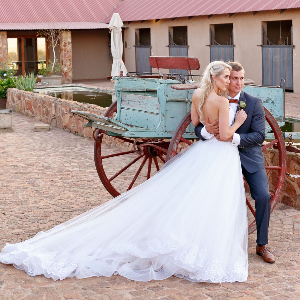the bride and groom posing with the horses at Lezar Opstal Wedding Venue