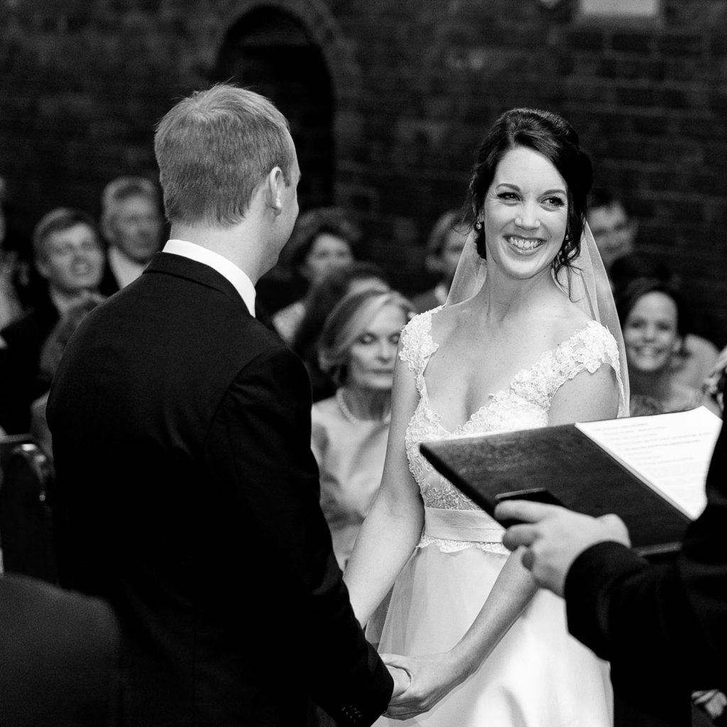 The bride smiling at the priest at St George's Anglican Church in Parktown Johannesburg