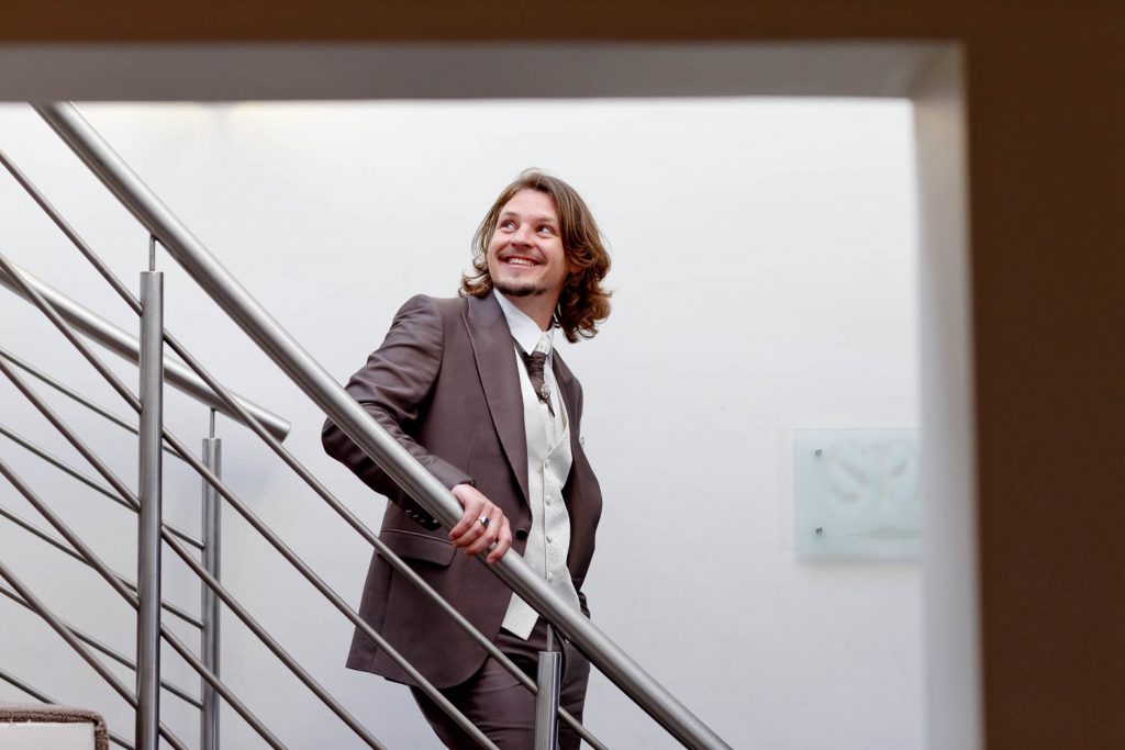 Greek Groom standing on the stairs at St Andrews Hotel and Spa