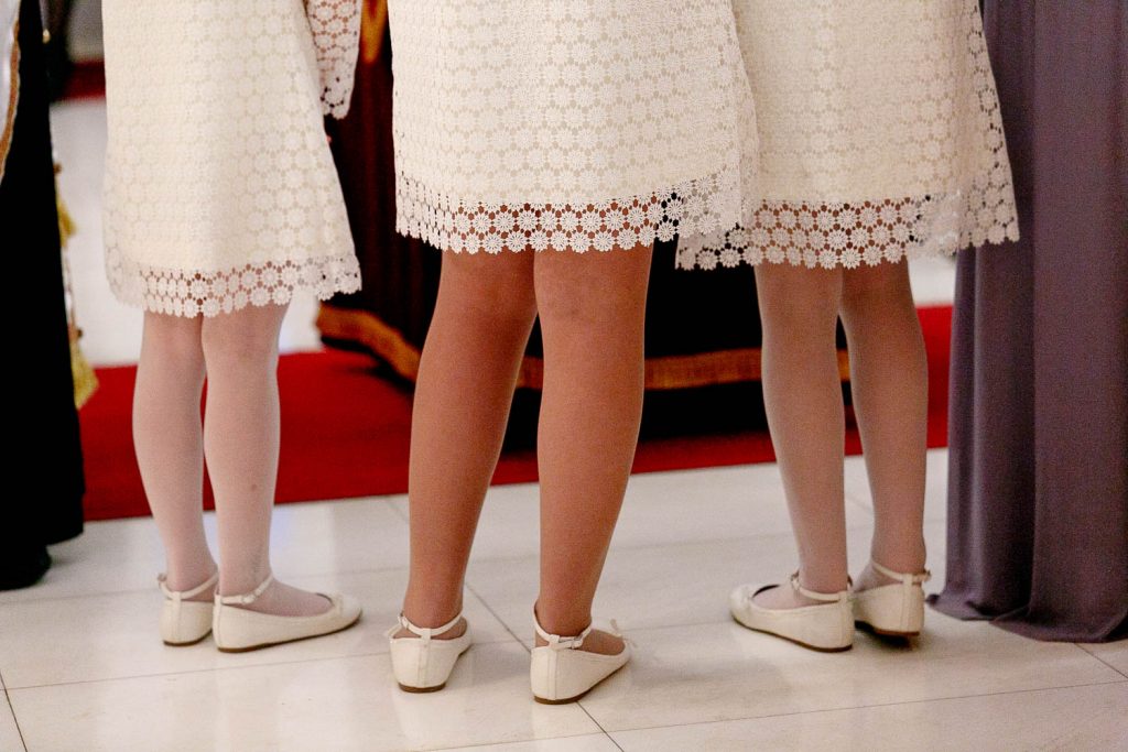 Flower girls little white wedding shoes at Saheti Greek Orthodox Church