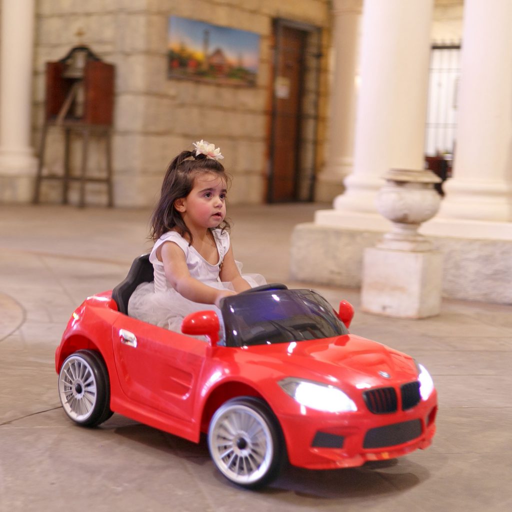 Little girl driving her electronic red BMW car at Our Lady of Cedars in Woodmead