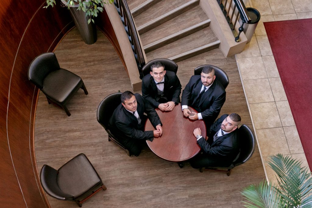 Men in black wedding suits sitting around the table at the Wanderers Club in Johannesburg