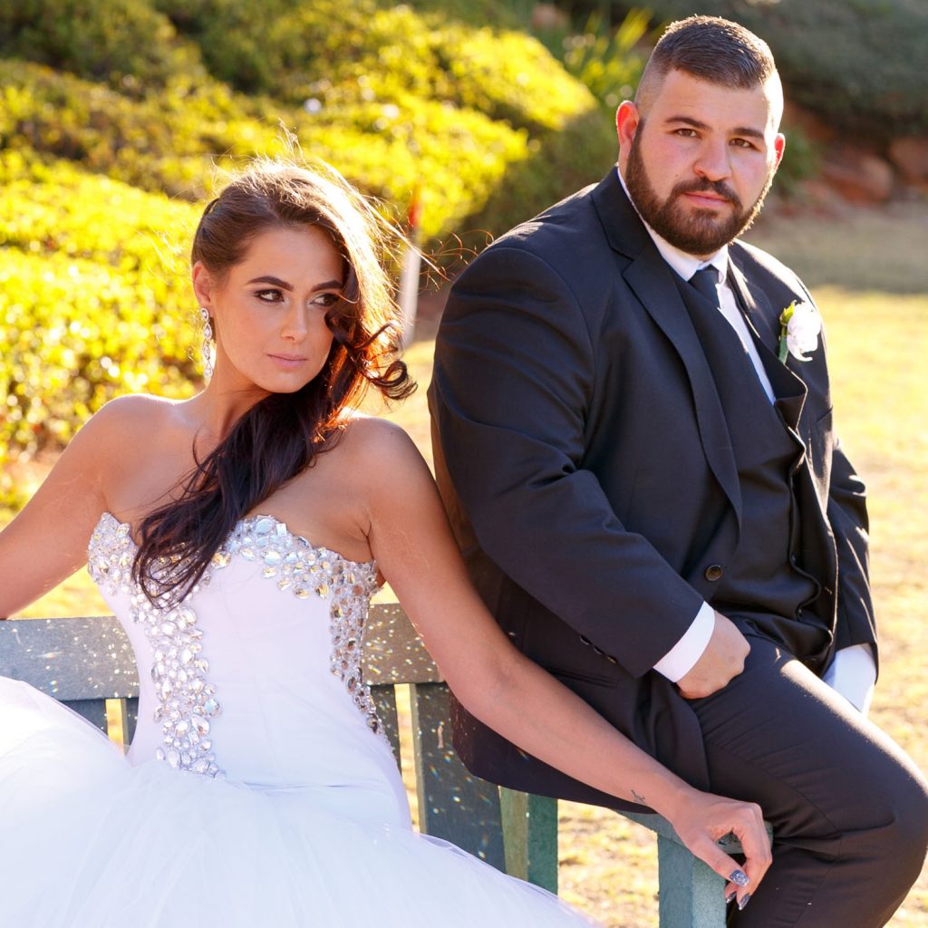 Wedding couple sitting on a bench under the African sky at the Wanderers Club